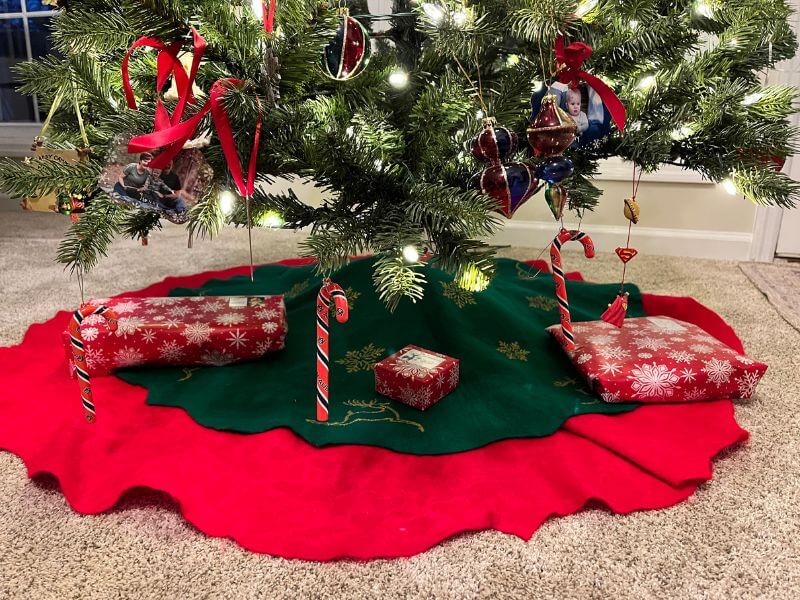 Christmas tree decorated with lights and ornaments, with few gifts underneath