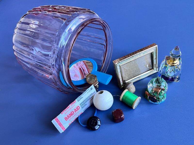 Glass jar holding twelve meaningful objects representing monthly focus words for the year Shift