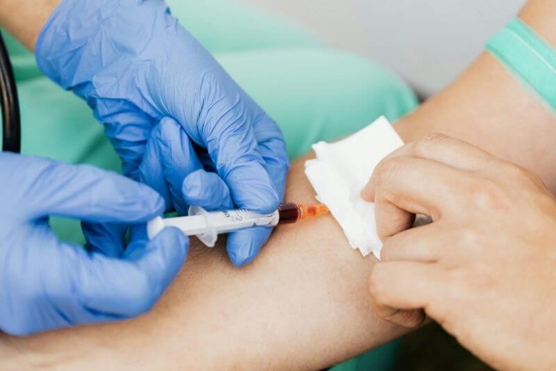 Nurse carefully drawing blood from a patient